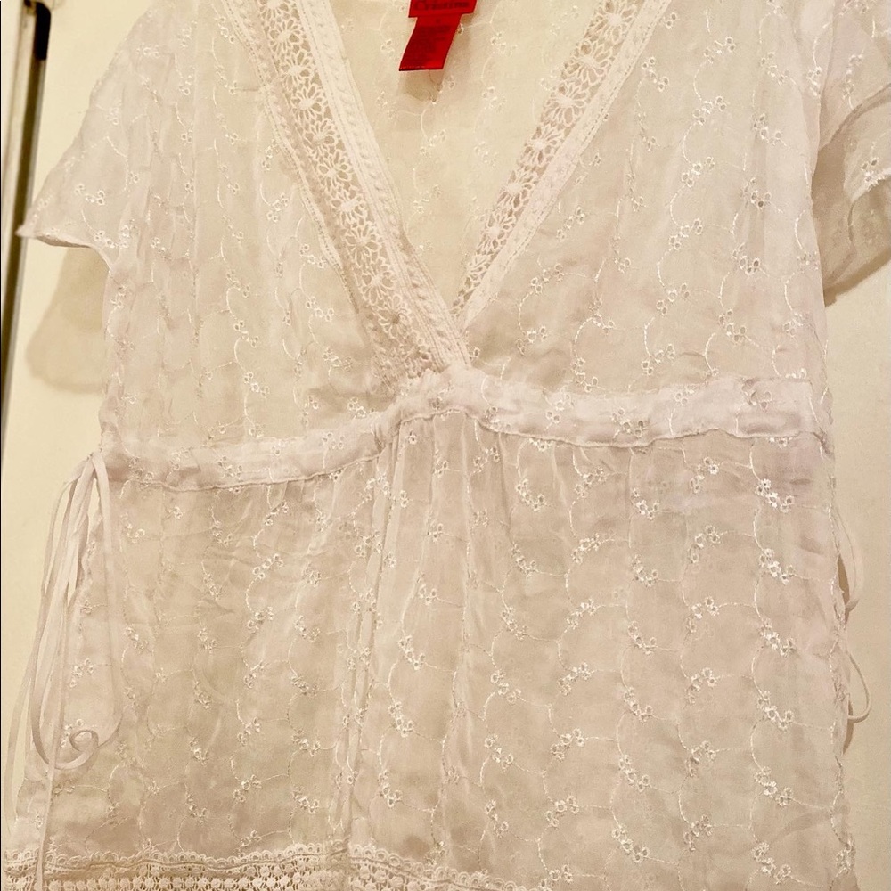 Sheer blouse designed with floral embroidered detail & adjustable sides.